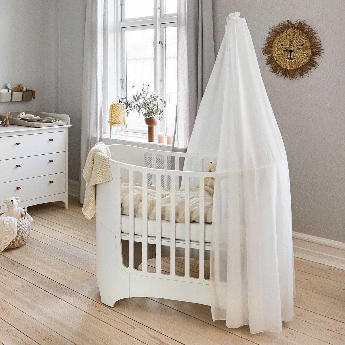 White baby cot with nursery accessories