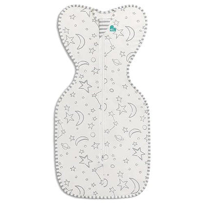 A cream-colored baby swaddle with stars and moons pattern, featuring a zip-up front.